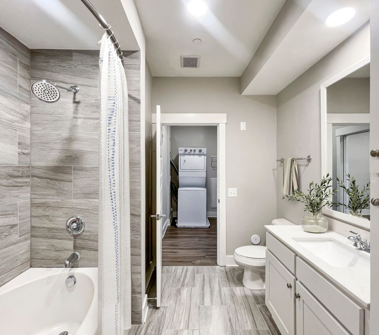 Gorgeous apartment bathroom with large soaking tub, rain showerhead, and large mirror