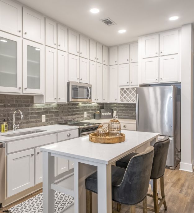A beautiful apartment kitchen with high-end finishes included a moveable kitchen island, floor to ceiling cabinetry, and stainless steel appliances