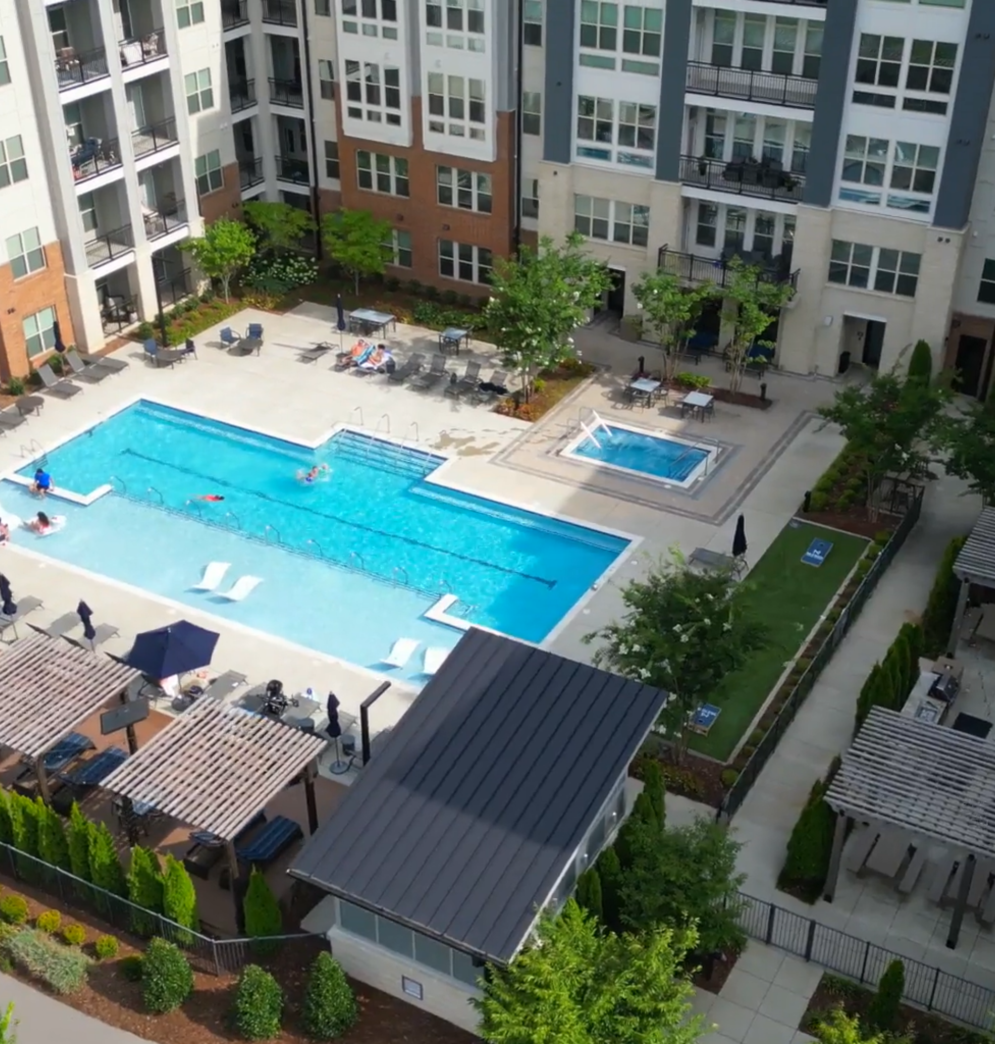 Beautiful view of McEwen Northside Apartment's luxury outdoor pool at night with seating and umbrellas