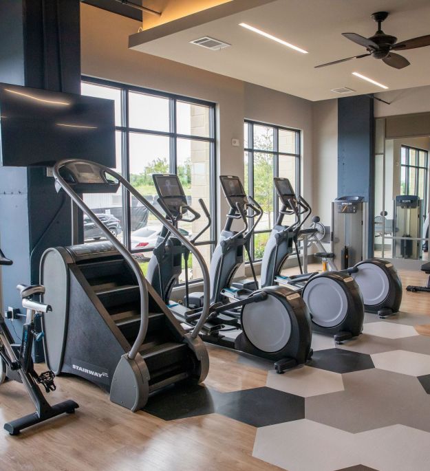 Cardio machines, including Peloton, Stairway, and elliptical at McEwen Northside Apartments