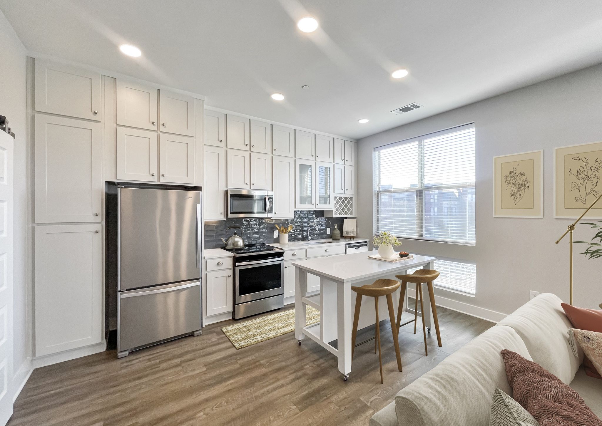 Luxury apartment kitchen with moveable kitchen island and stainless steel appliances