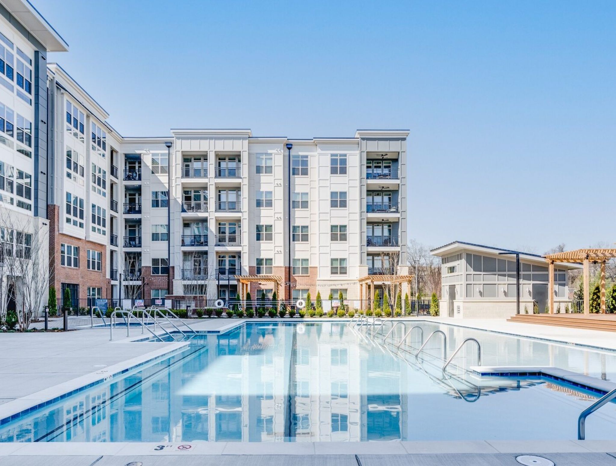 Zero entry pool surrounded by palm trees and overlooking Tampa Bay at The Emerson On Rocky Point apartments