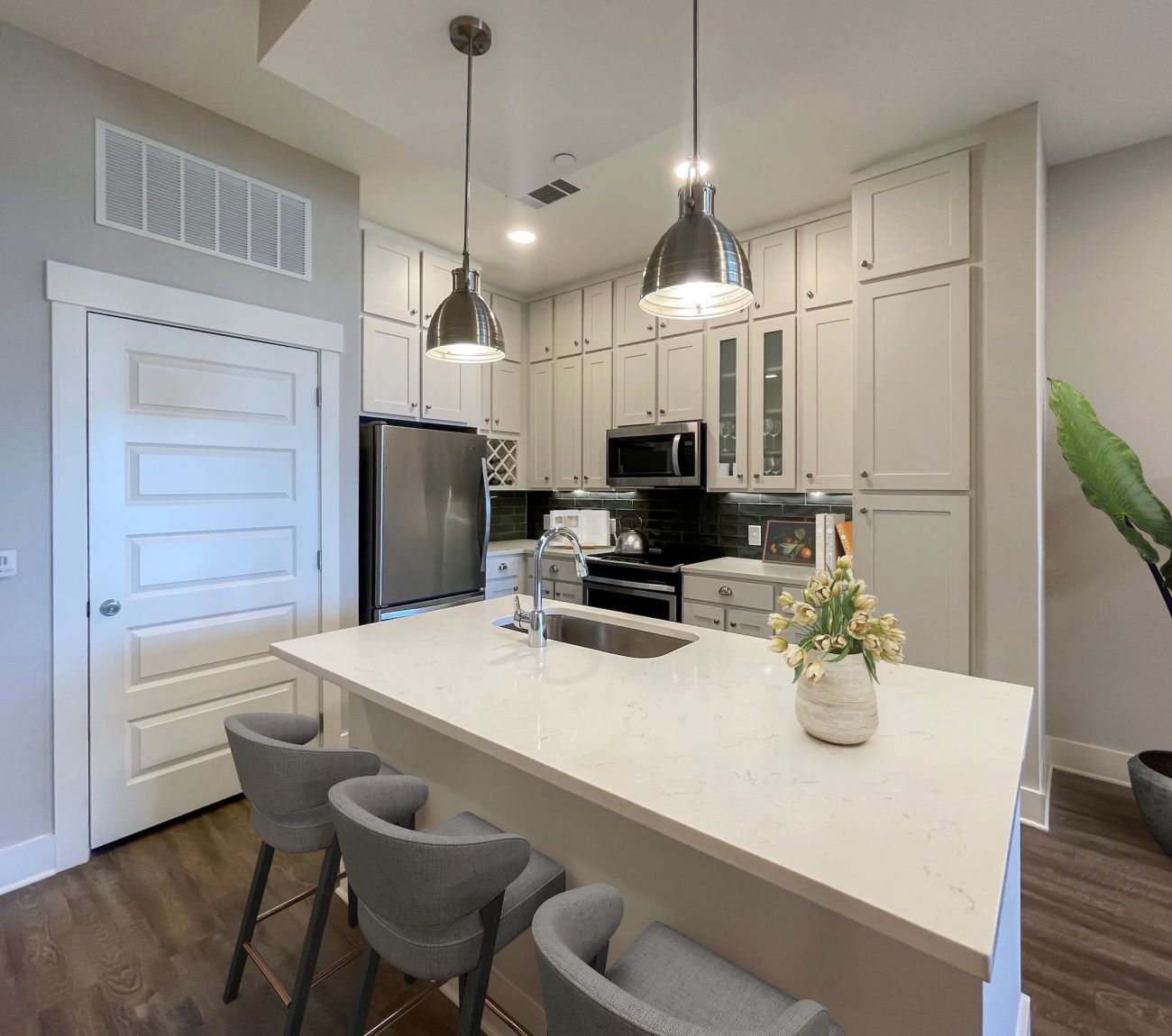 Luxury apartment kitchen with large kitchen island, deep sink, pendant lighting, and high-end finishes