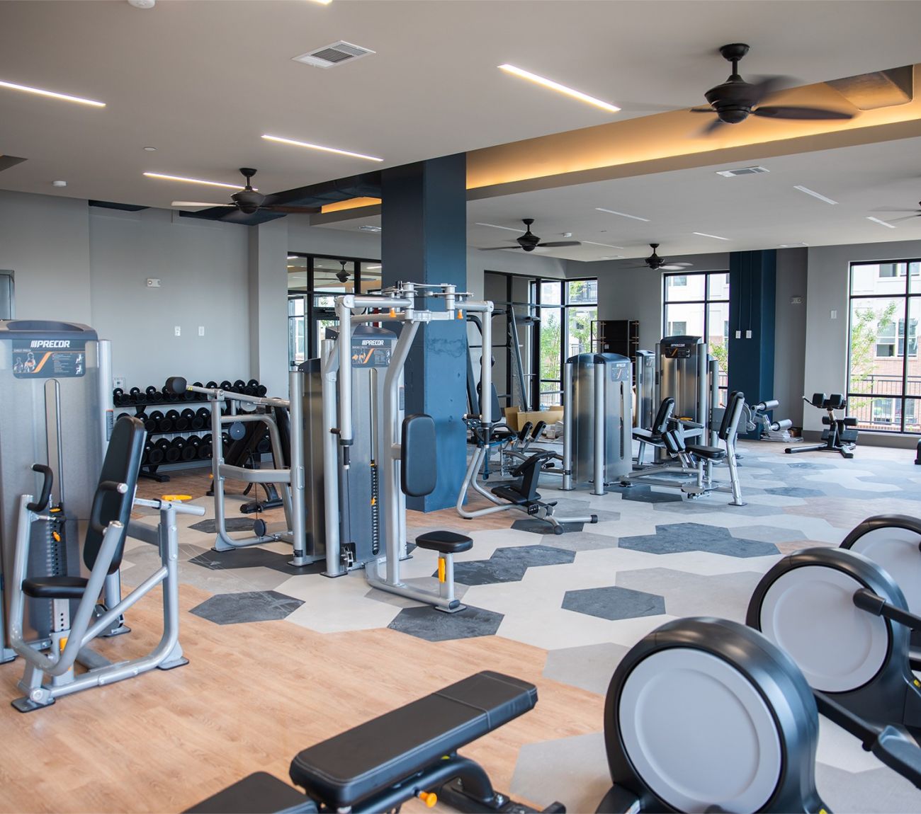 Expansive fitness center at McEwen apartments with lots of exercise equipment and machines