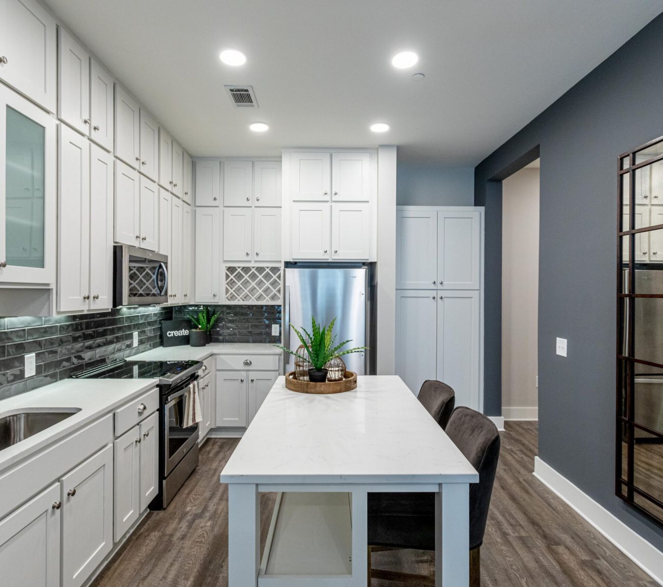 Luxury apartment kitchen with large kitchen island, deep sink, pendant lighting, and high-end finishes