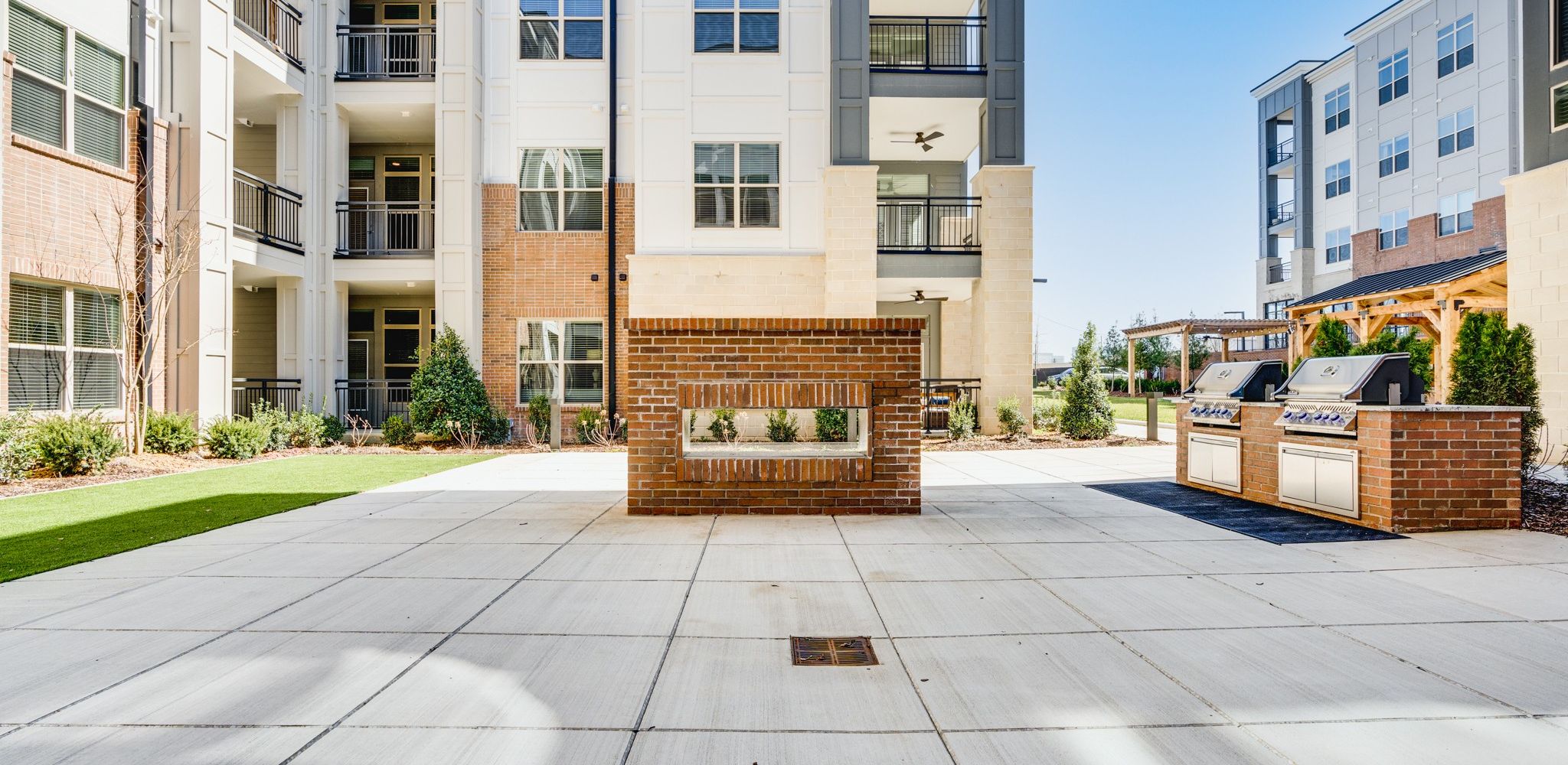 Large outdoor kitchen featuring gas grills on concrete pad