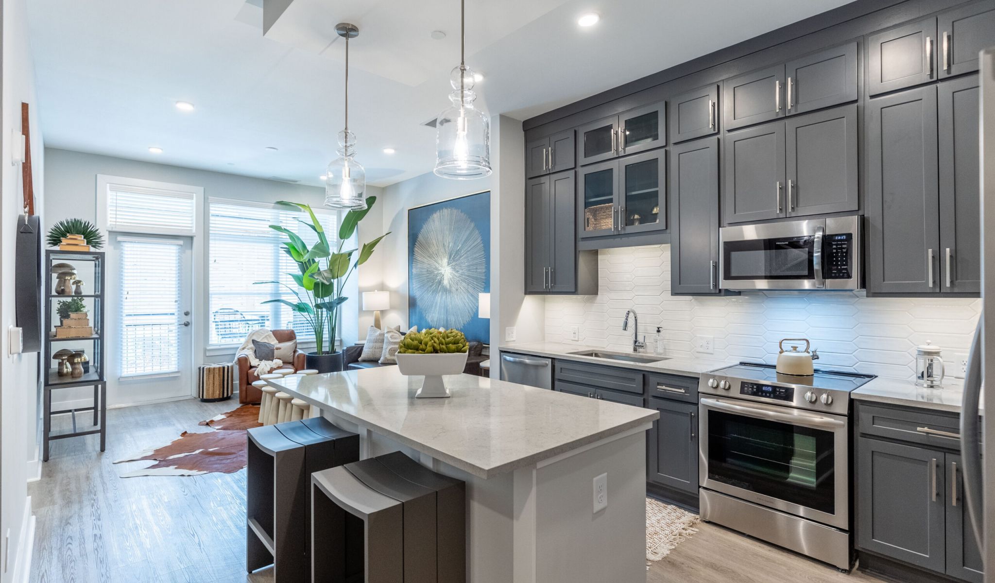 McEwen Apartments kitchen with dark cabinets, island, and stainless steel appliances