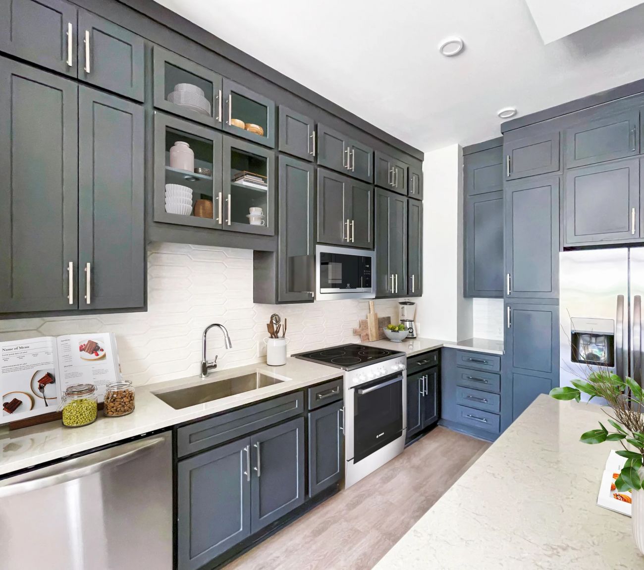 McEwen Apartments kitchen with dark cabinets, island, and stainless steel appliances