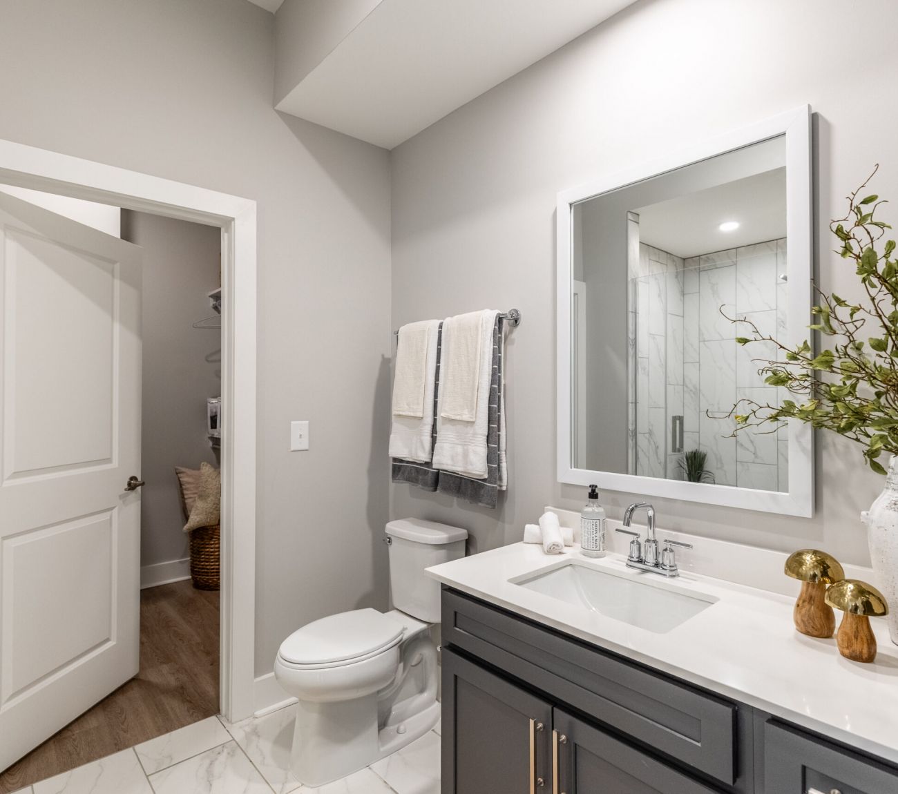 Gorgeous apartment bathroom with large soaking tub, rain showerhead, and large mirror