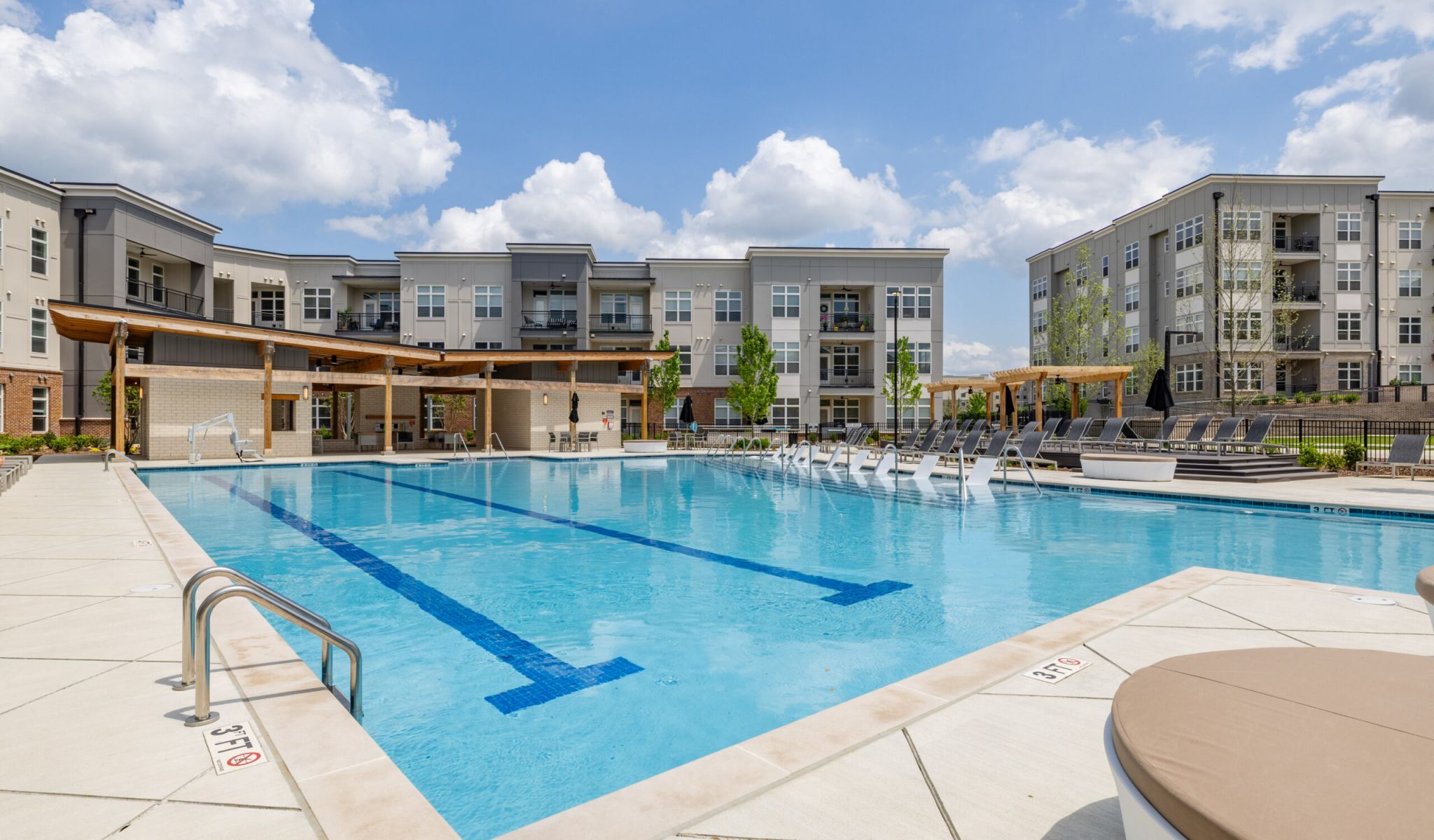 Outdoor apartment pool with sun shelves & built-in seating